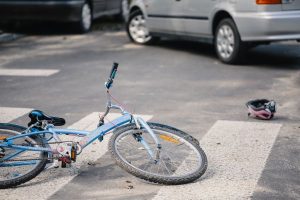 New law in NJ aims to eliminate traffic accident fatalities for drivers, bicyclists, pedestrians and passengers - blue 10 speed bike lying in crosswalk with car nearby